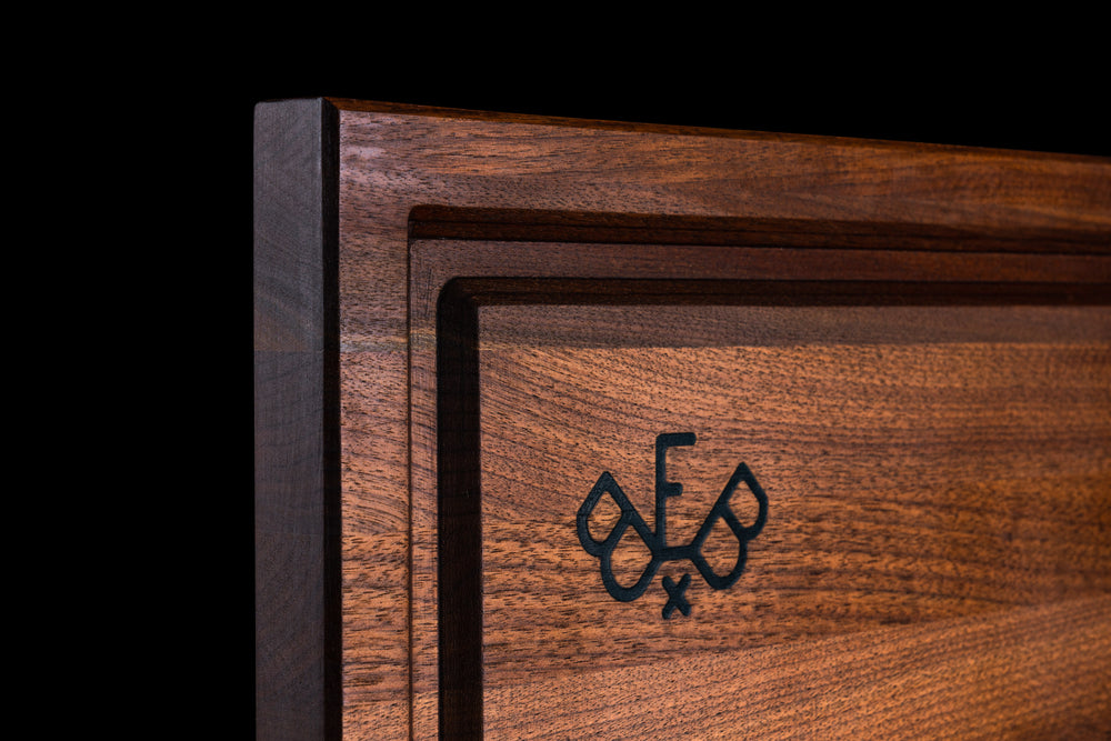 Corner of the walnut board from the side, showing the juice groove and the thickness of the edge grain