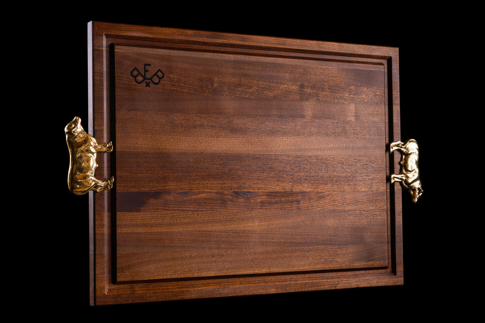 Pitmaster board in walnut at an angle, showing the juice groove and the brass Bull handles